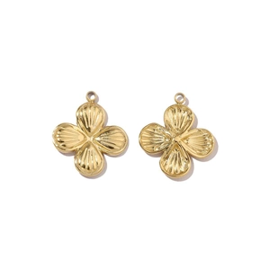 Close-up of golden clover pendants with shell texture and mirror polished finish
