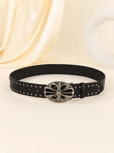 Close-up of a punk style black leather belt with vintage silver studs and floral buckle