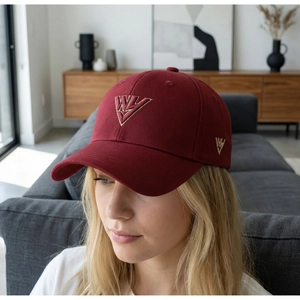 Modello che indossa un cappellino da baseball bordeaux con ricamo dorato