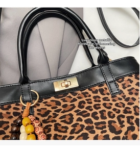 Dettaglio ravvicinato della chiusura a scatto in metallo dorato su borsa leopardata