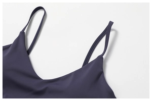Detail of V-neckline and spaghetti straps on a dark purple quick-dry athletic top