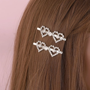 Sparkling silver heart hair clip with crystals worn on brown hair as a side accessory