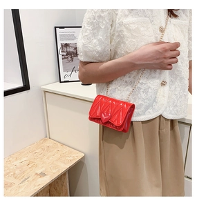 Girl's red heart silicone crossbody bag with gold chain strap shown in indoor setting