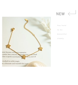Detailed view of a gold star charm bracelet with zircons on a vintage paper background