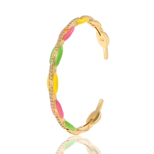Detail view of gold enamel bangle with colorful pink yellow green drip oil and rhinestones