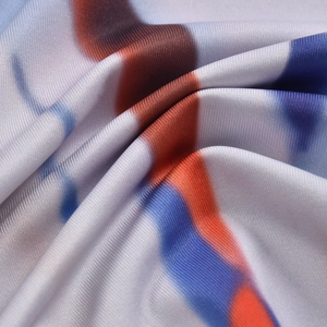 Detail of ribbed knit fabric with vibrant blue, orange, and white gradient print patterns