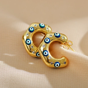 C-shaped gold earrings with colorful devil eye enamel patterns and sparkling small diamonds