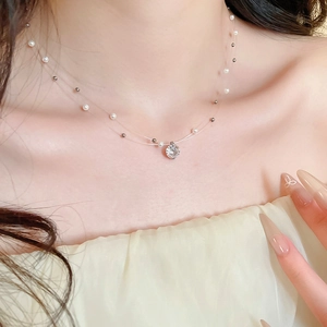 Macro detail of double-layer necklace with white pearls and sparkling zircon pendant
