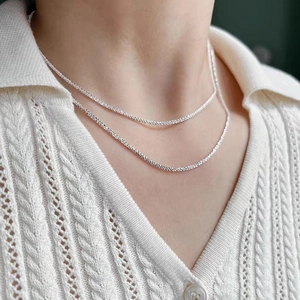 Double-layered 925 silver shimmering choker necklace worn by a model in soft light