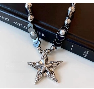 Gros plan du collier étoile Y2K avec chaîne perlée métallique et détails punk
