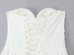 Detail of white tube dress featuring back lace-up closure and side invisible zipper
