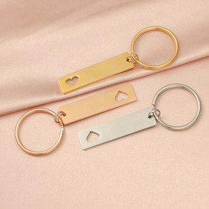 Three hollow heart rectangle keychains in gold, rose gold and silver on pink silk