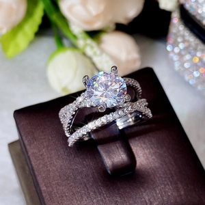 Macro shot of silver four-prong round zircon ring with pavé stones on twisted band