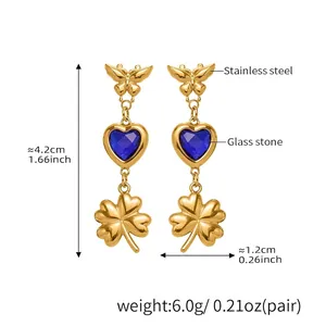 Detail showing gold stainless steel butterfly earrings with blue heart stone and clover charm