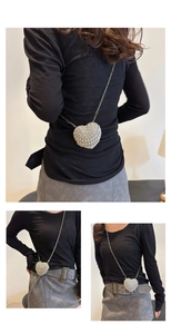Vue en trois parties d'un sac de soirée en strass en forme de cœur avec chaîne sur un modèle