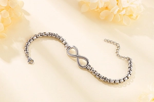 Détail du symbole infini en argent sur un bracelet en maille jante en acier inoxydable