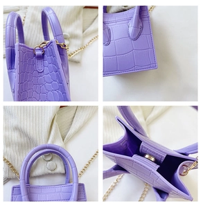 Detail view of purple crocodile pattern tote bag featuring gold chain and magnetic closure
