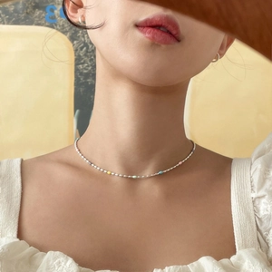 925 silver rainbow beaded choker necklace worn by a model on a warm yellow background