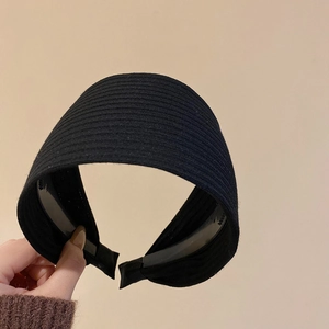 Detailansicht des schwarzen breiten Strickstirnbandes mit feiner gerippter Stoffstruktur