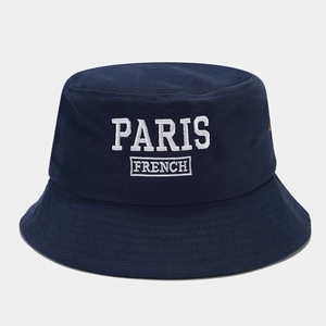 Detailed view of white PARIS FRENCH letter embroidery on navy blue cotton bucket hat