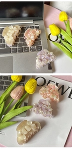 Detailed view of 3D floral hair claws with pearlescent finish and crystal center accents