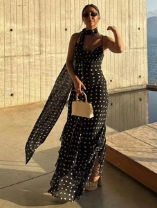 Polka dot dress detail featuring matching neck scarf and ruffled hemline on black fabric