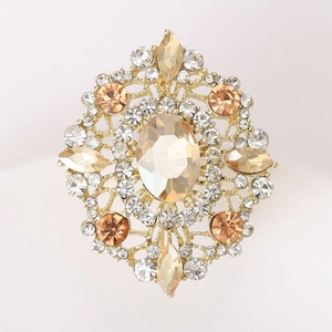 Macro shot of vintage golden brooch with champagne crystal and detailed rhinestone pattern