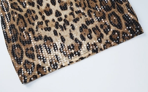 Detailed macro view of leopard print sequins and double-stitched hem on this stylish dress