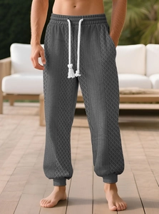 Détail du jogging gris pour homme avec textures de tricot torsadé et motifs à losanges