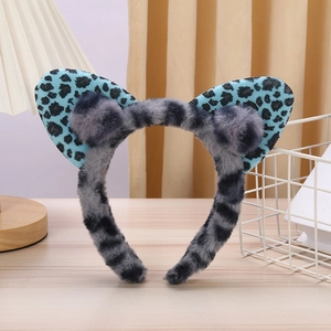 Detailed view of gray plush cat ear headband with blue leopard print and fluffy pom-poms