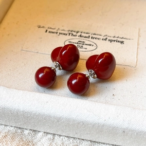 Gros plan de boucles d'oreilles élégantes en forme de cœur rouge sur fond de lin texturé