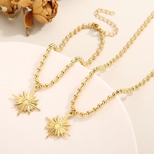 Détail macro de pendentifs étoile en plaqué or 18 carats sur un support minimaliste