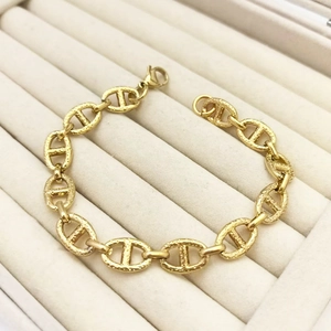 Macro shot of gold-plated punk style link bracelet with frosted texture and lobster clasp
