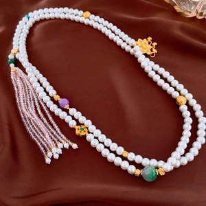Detail of vintage glass pearl sweater necklace with gemstone beads and long tassels