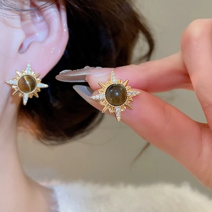 Detail of 18K gold plated sunburst earrings with tiger eye stone and crystals