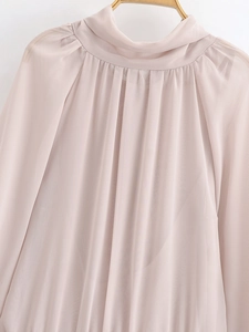Detail of light pink chiffon blouse featuring pleated high neck and long sleeves
