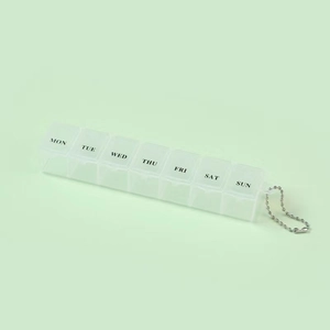 Portable 7-day pill organizer with metal chain and weekly labels on green background