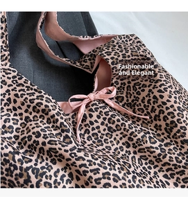 Detail of leopard print tote bag featuring a pink lining and stylish bow decoration