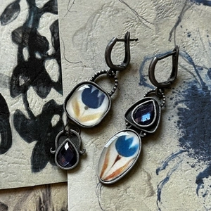Detail of vintage Egyptian enamel earrings with blue floral motifs and purple gems