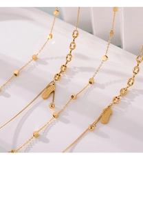 Gros plan d'une chevillère en titane plaqué or avec pendentif carré et maille fine