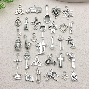 Detailed grid layout of antique silver alloy charms featuring keys, crosses, and wine bottles