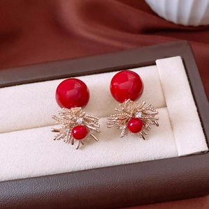 Detailed macro view of 18k gold plated pearl flower earrings with red crystal beads