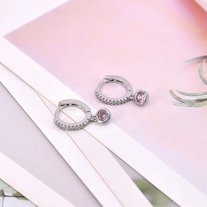 Macro shot of silver drop earrings with pink zircon stone and pavé crystal hoop