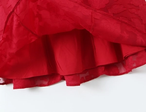 Gros plan sur l'ourlet en tissu jacquard rouge avec doublure sur la robe de mode
