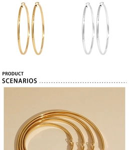 Detail view of large gold and silver polished stainless steel hoop earrings with clasp