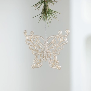 Sparkling champagne gold butterfly ornament hanging on green Christmas tree branch