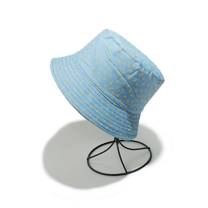 Detail of light blue denim bucket hat with yellow floral print and reinforced stitching