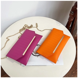 Detail of rose red and orange pleated PU leather clutches with gold chain straps