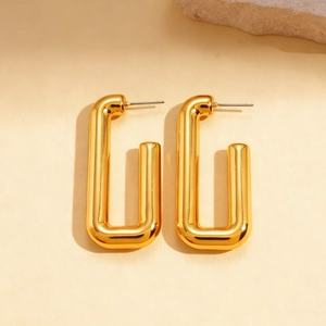 Macro shot of gold rectangle U-shaped stud earrings with polished metal finish