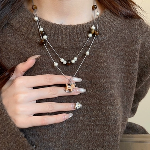 Détail du collier double rang avec perles, œil de tigre et un petit pendentif cheval en bois